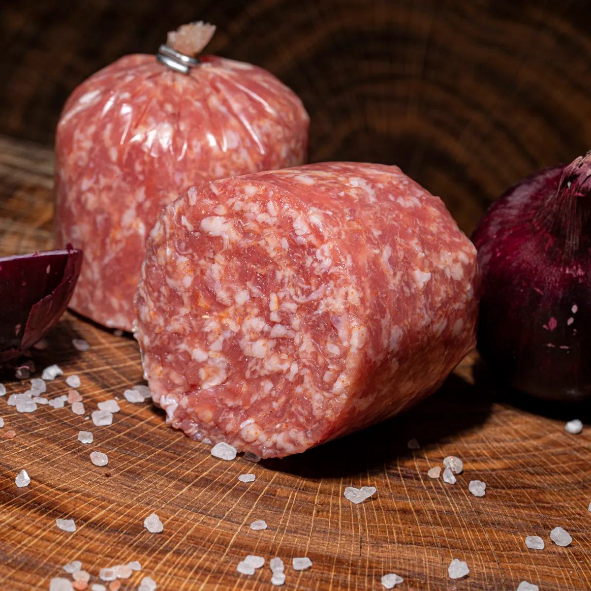 Eine halbierte Zwiebelmett mit Zwiebel als Deko auf Holztisch.
