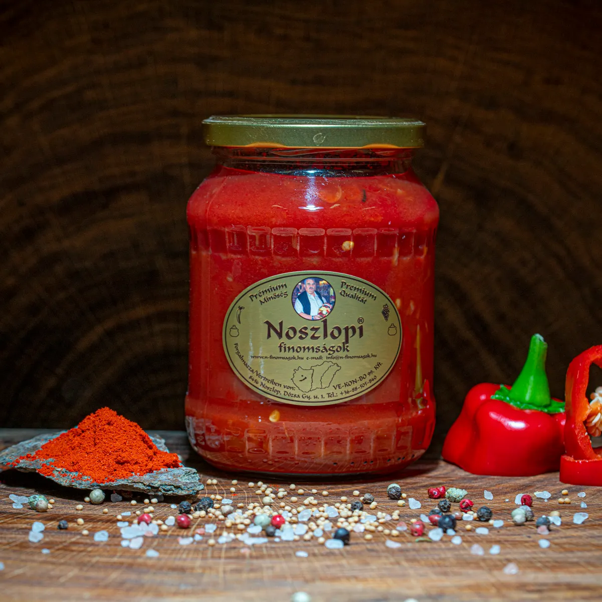 Noszlopi ungarisches Letscho jetzt probieren. Noszlopi ungarisches Letscho im Glas mit Paprika Deko auf einer Holzplatte.