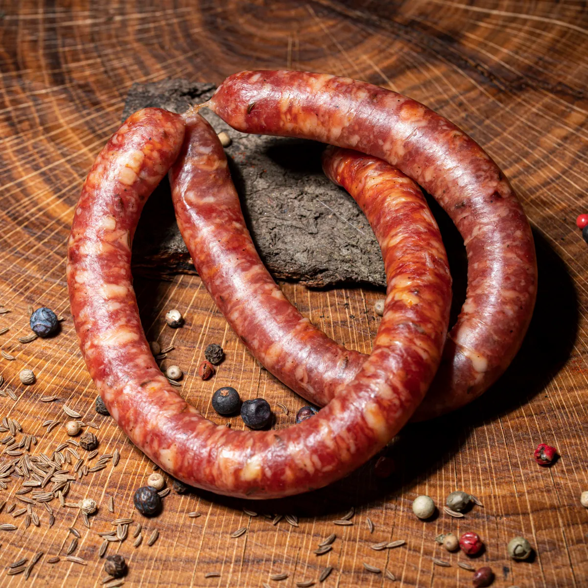 Würzige Rauchpeitschensind der ideale Snack für unterwegs. Pärchen Rauchpeitschen aus Schweinefleisch auf Holztisch.