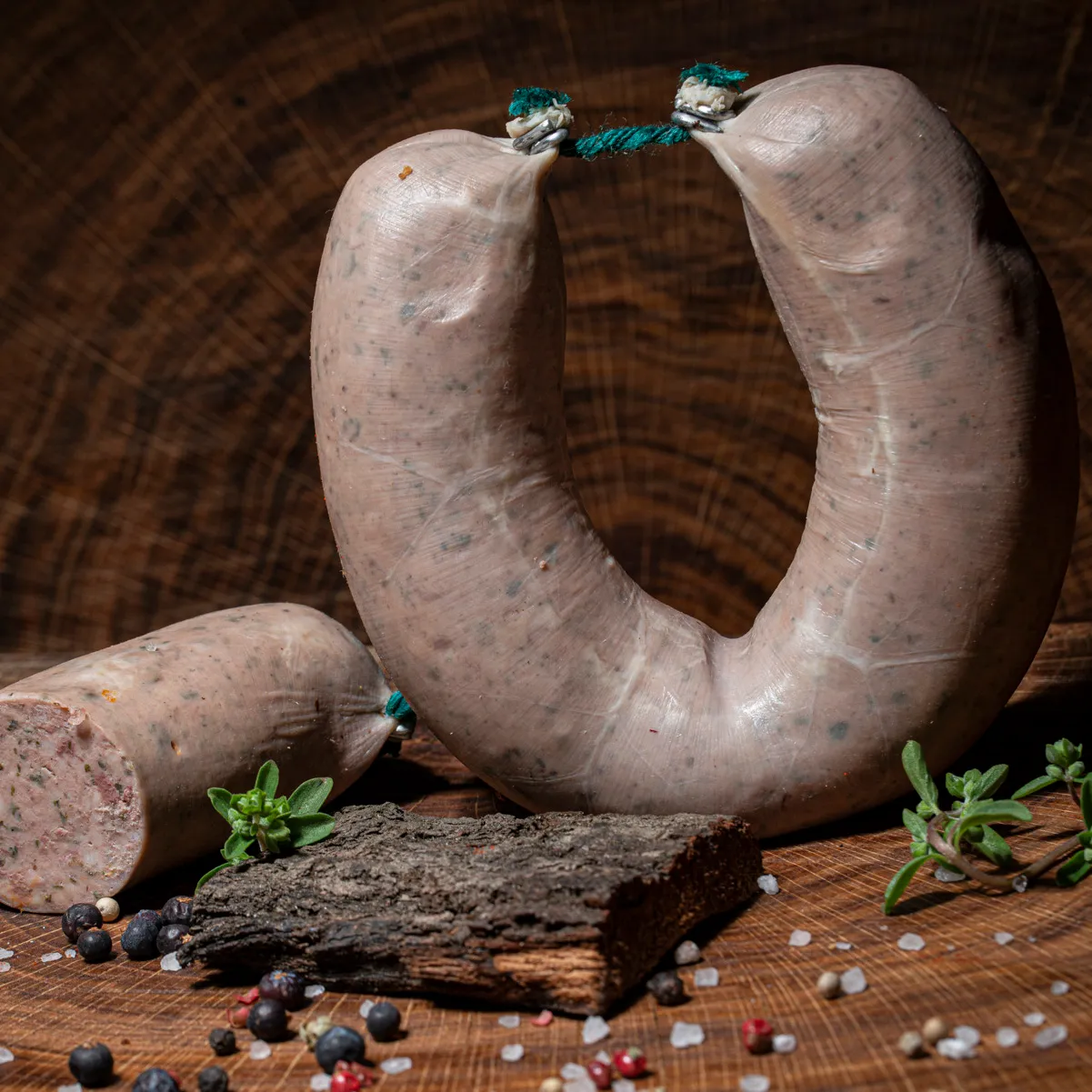 Hausmacher ungeräucherte Leberwurst ganzer Ring und angeschnitten mit Majoran, Salz und Pfeffer als Deko.