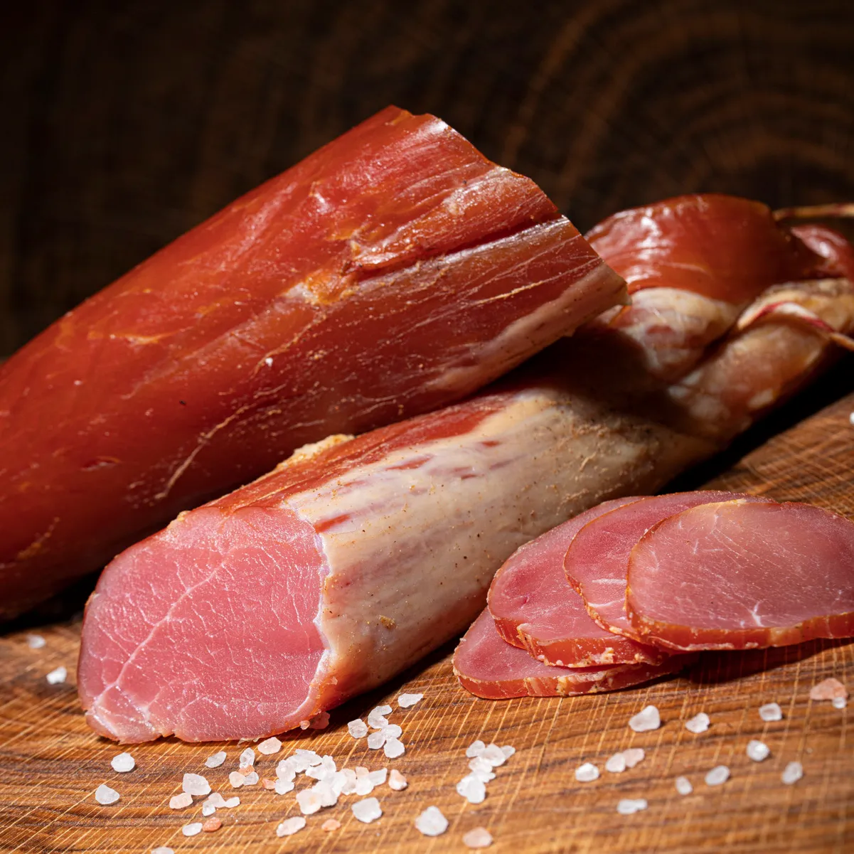 Jetzt die feine Räucherlende als ideale Spezialität in der Küche bestellen! Räucherlende geschnitten auf einem Holzbrett.