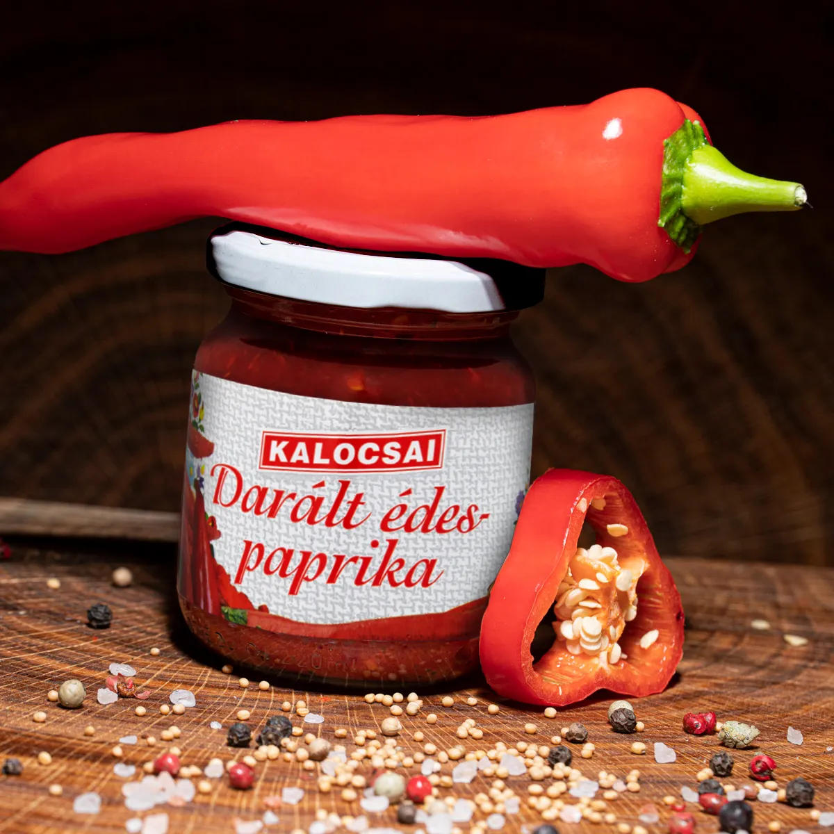 Kalocsai ungarisches Paprikapuerree mild online kaufen. Kalocsai ungarisches Paprikapuerree mild im Glas mit Deko auf Holzbrett.