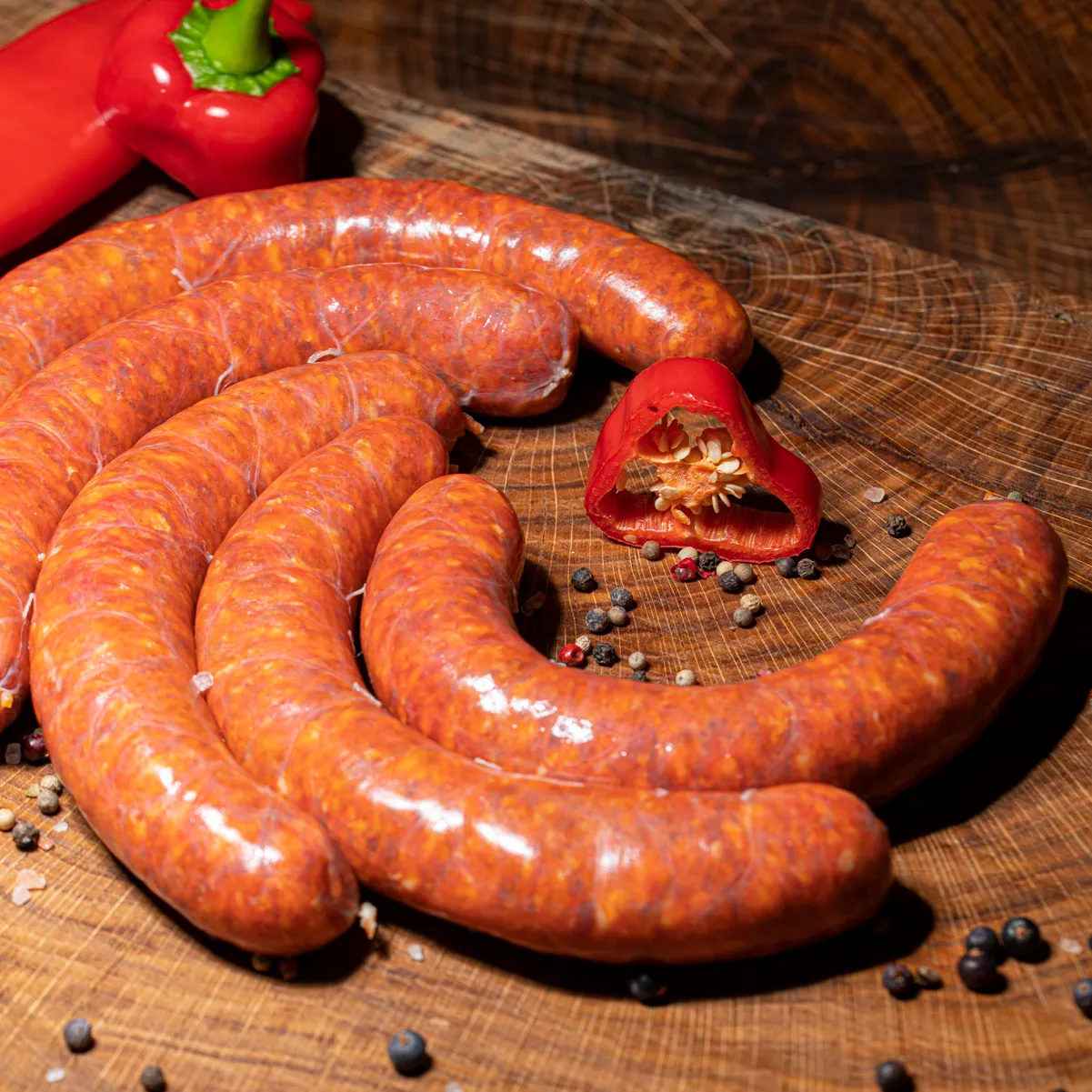 Ungarische frische Kolbasz 5 Stück aufgefächert auf Holzbrett.