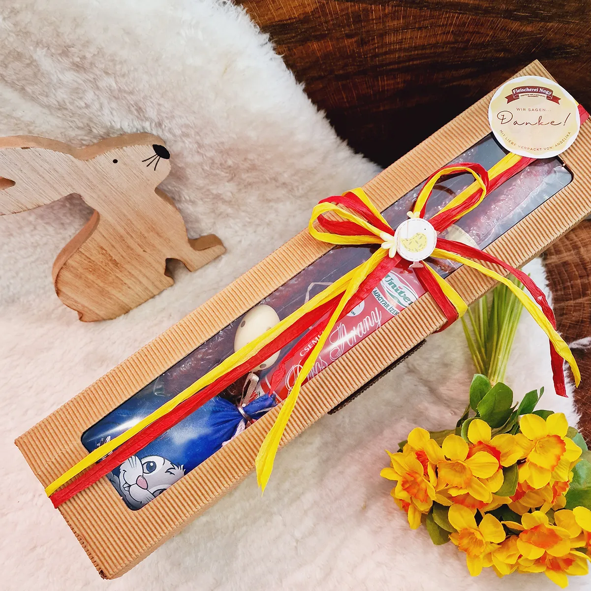 Osterzauber Box mit Wurstspezialitäten verpackt mit Schleife und Osterdeko.