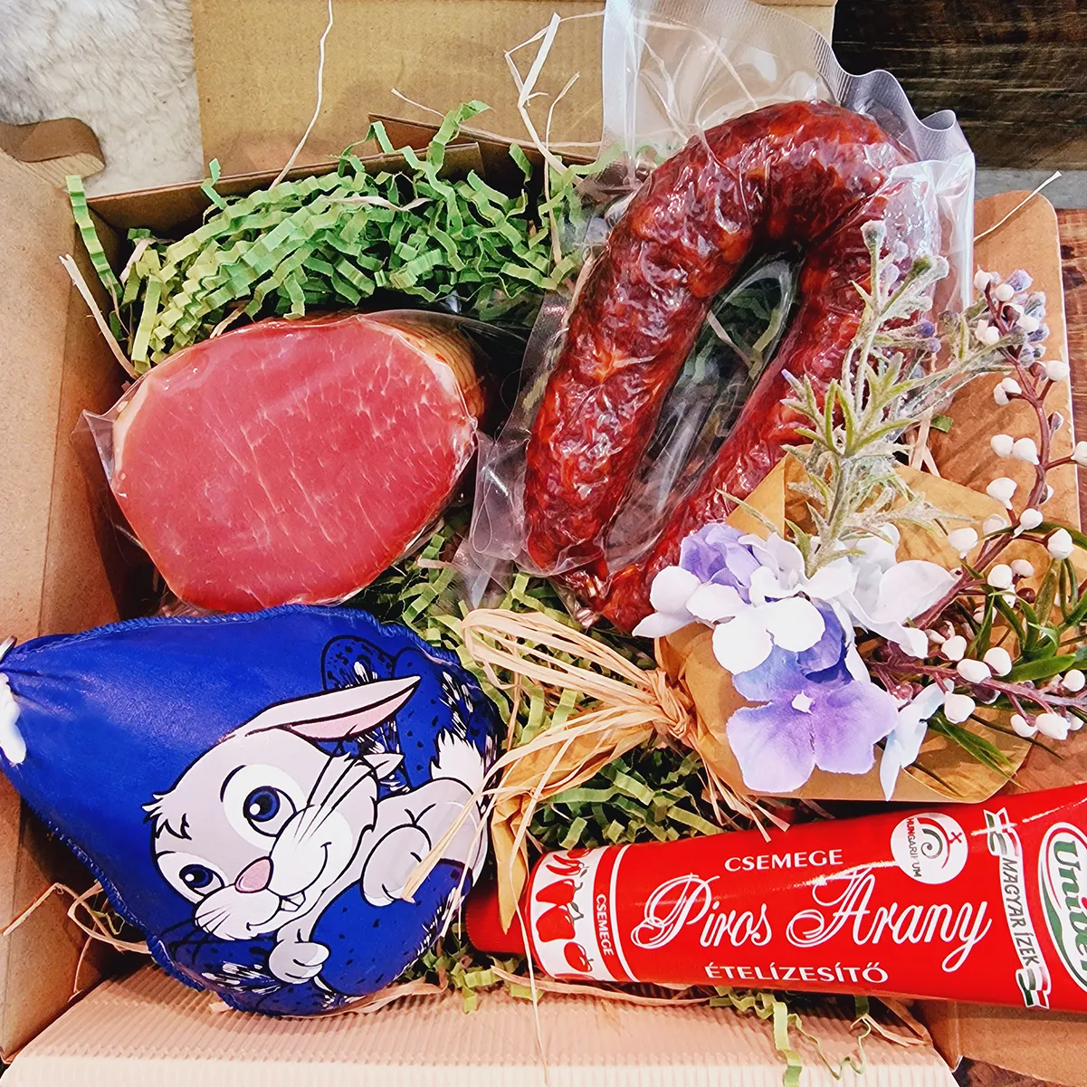 Eine Osterpräsentbox mit würziger Feinkost wie Rollschinken und Höllenwurst sowie scharfer Gulaschcreme.