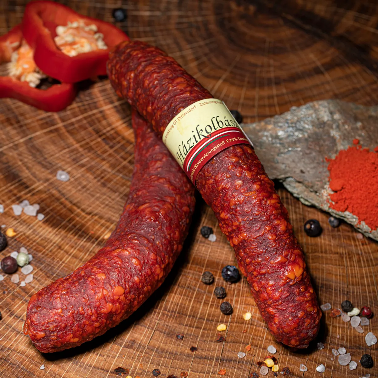 Jetzt unsere ungarische Spezialität Haszikolbasz bestellen! Ungarische Wurst Haszikolbasz mit Deko auf Tischplatte.