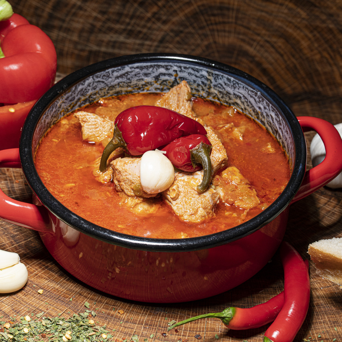 Entdecken Sie unseren hausgemachten Kesselgulasch! Hausgemachter Kesselgulasch im Topf mit Paprikaschoten.