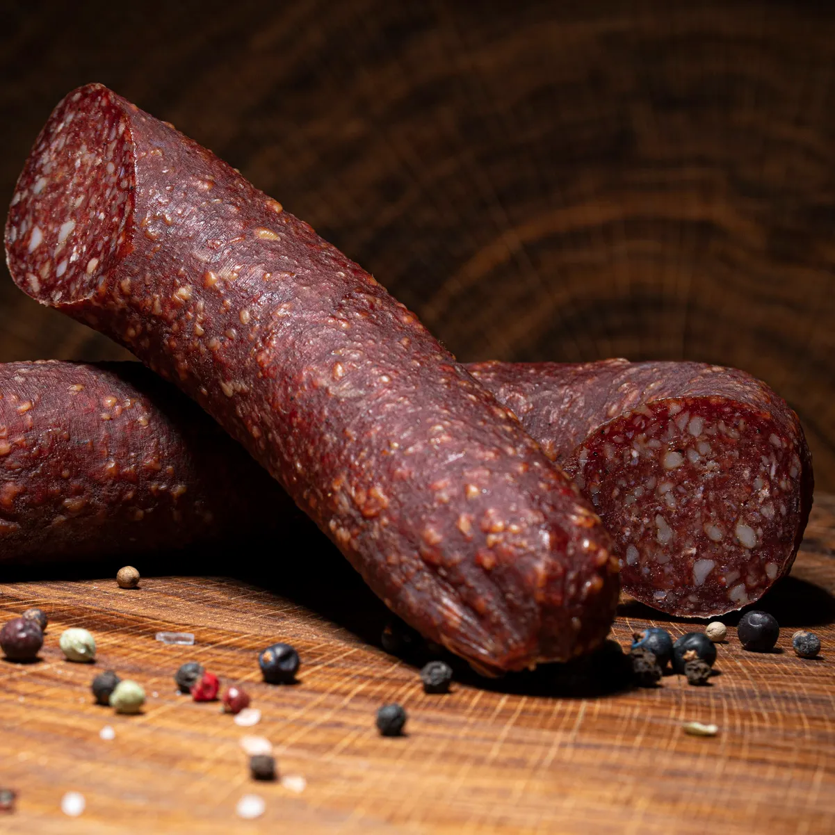 Entdecken Sie unsere Wurstspezialität, die Karpatensalami! Wurstspezialität Karpatensalami mit Lamm und Rind auf einem Holztisch.