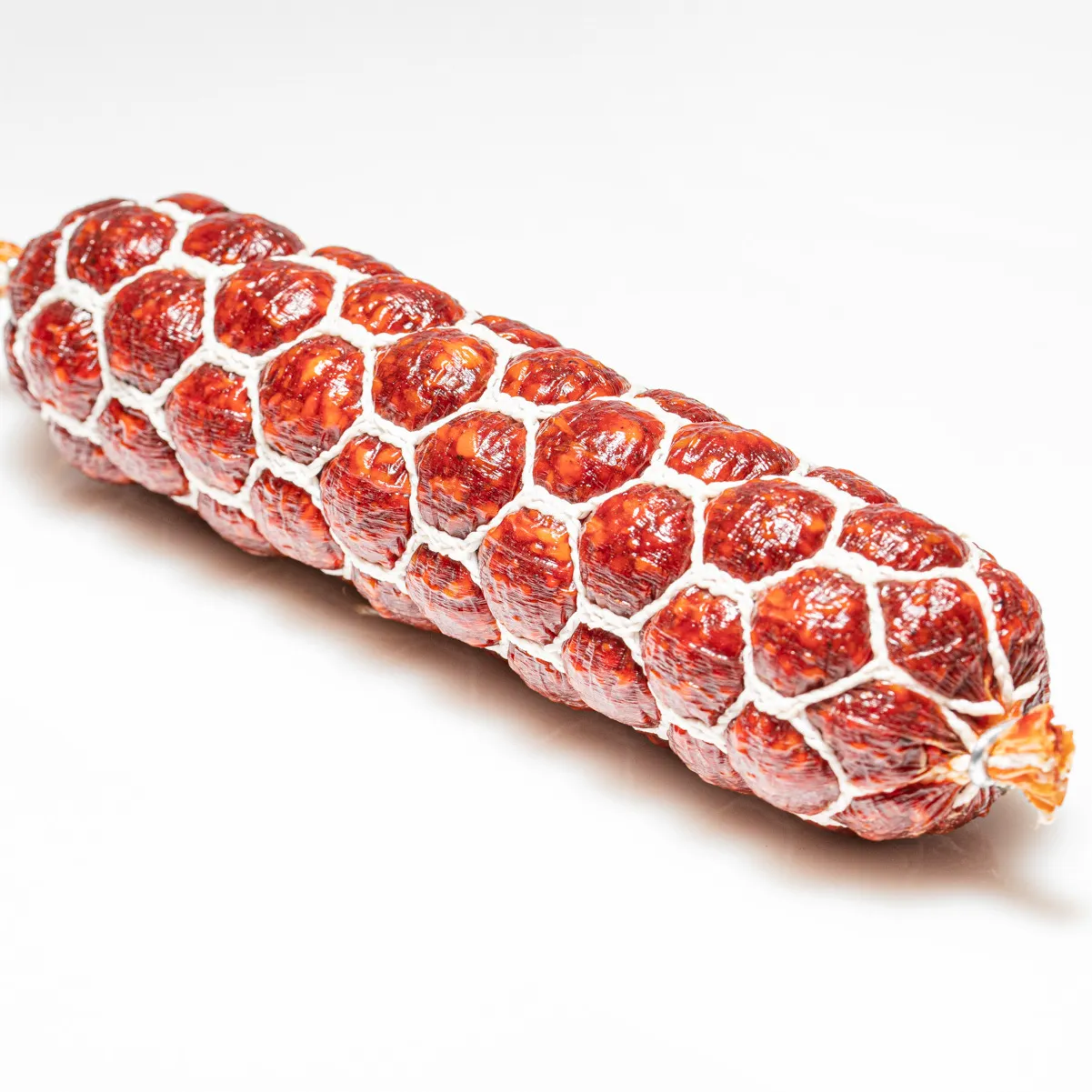 Probieren Sie unsere scharfe Teufelssalami in klein! Teufelssalami in kleinund im Ganzen vor weißem Hintergrund.