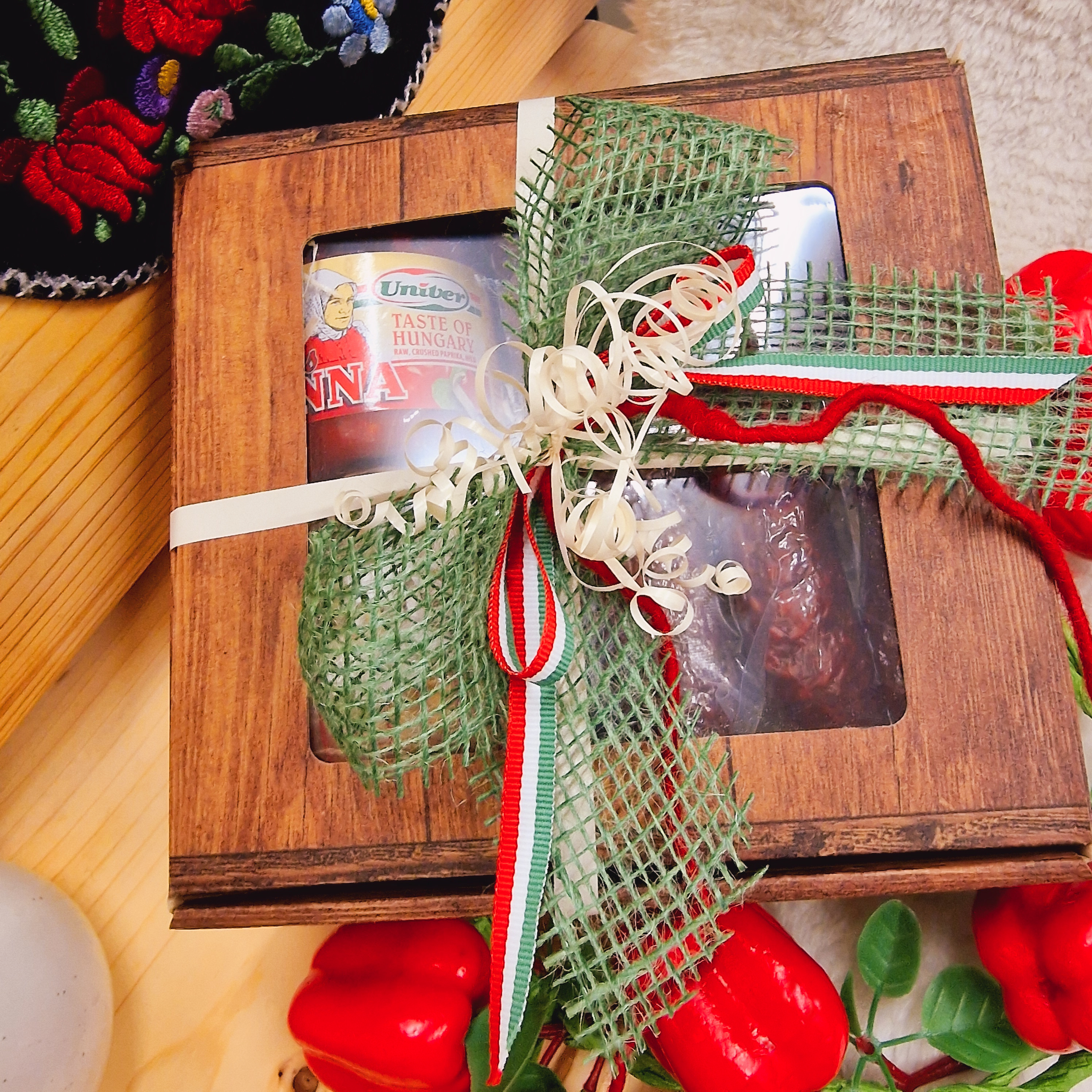 Geschlossene Geschenkbox mit Schleife und verschiedenen Wurstwaren als Inhalt.