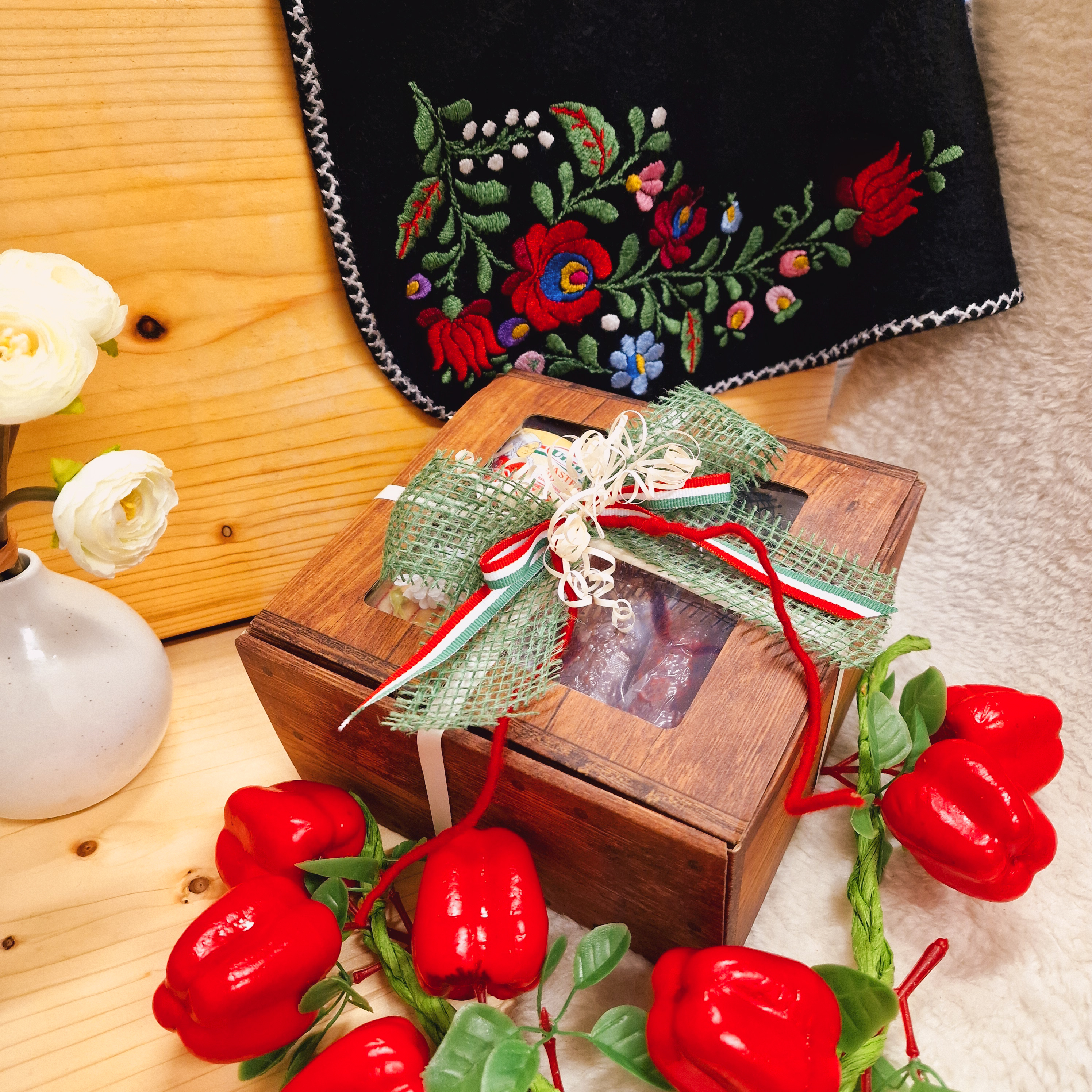 Geschlossene Geschenkbox mit Deko und Schleife; mit Wurstspezialitäten als Inhalt.