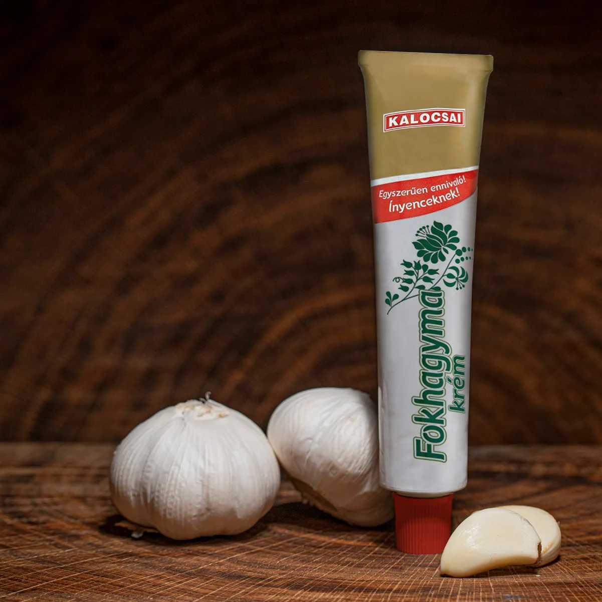 Kalocsai ungarische Knoblauchcreme jetzt bestellen. Kalocsai ungarische Knoblauchcreme Tube mit Knoblauchknollen auf Holzbrett.