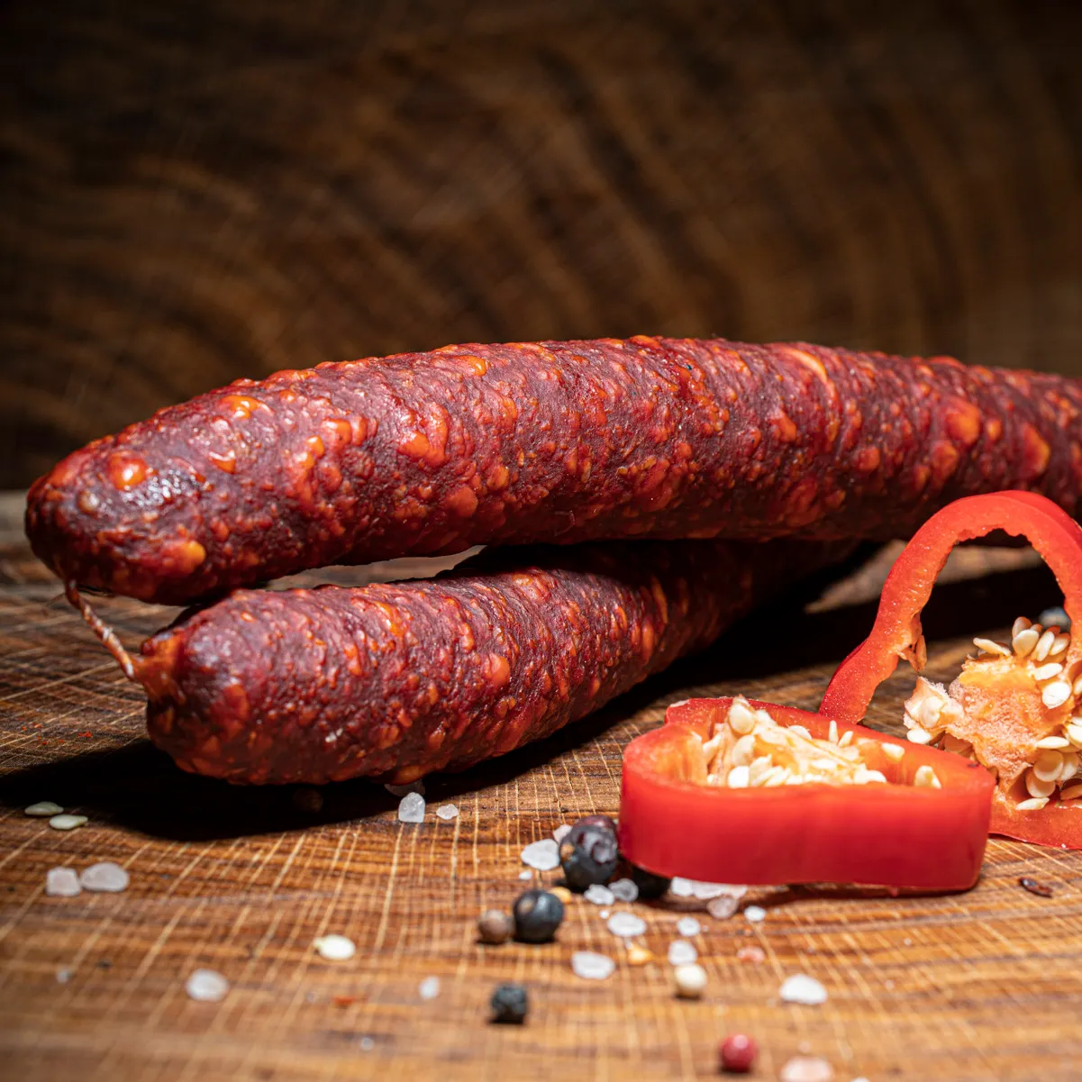 Jetzt unsere ungarische Spezialität Langolt-Kolbasz bestellen! Ungarische Wurst Langolt-Kolbasz mit Deko auf Tischplatte.