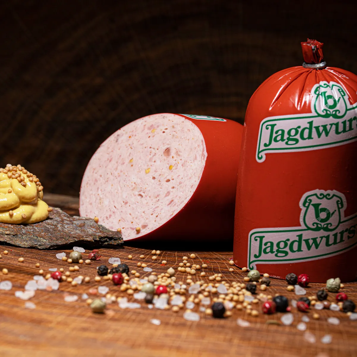 Jagdwurst auf Holzbrett mit Klecks Senf als Deko an der Seite.