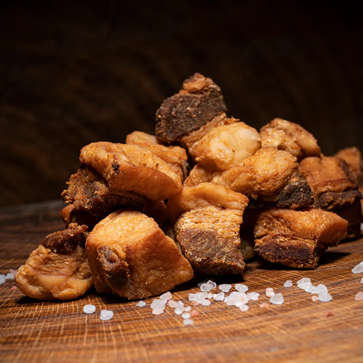 Ungarisches Tepertö, Speckgrieben gesalzen hier bestellen! Ungarische Speckgrieben gebacken mit Salz auf einem Holzbrett.