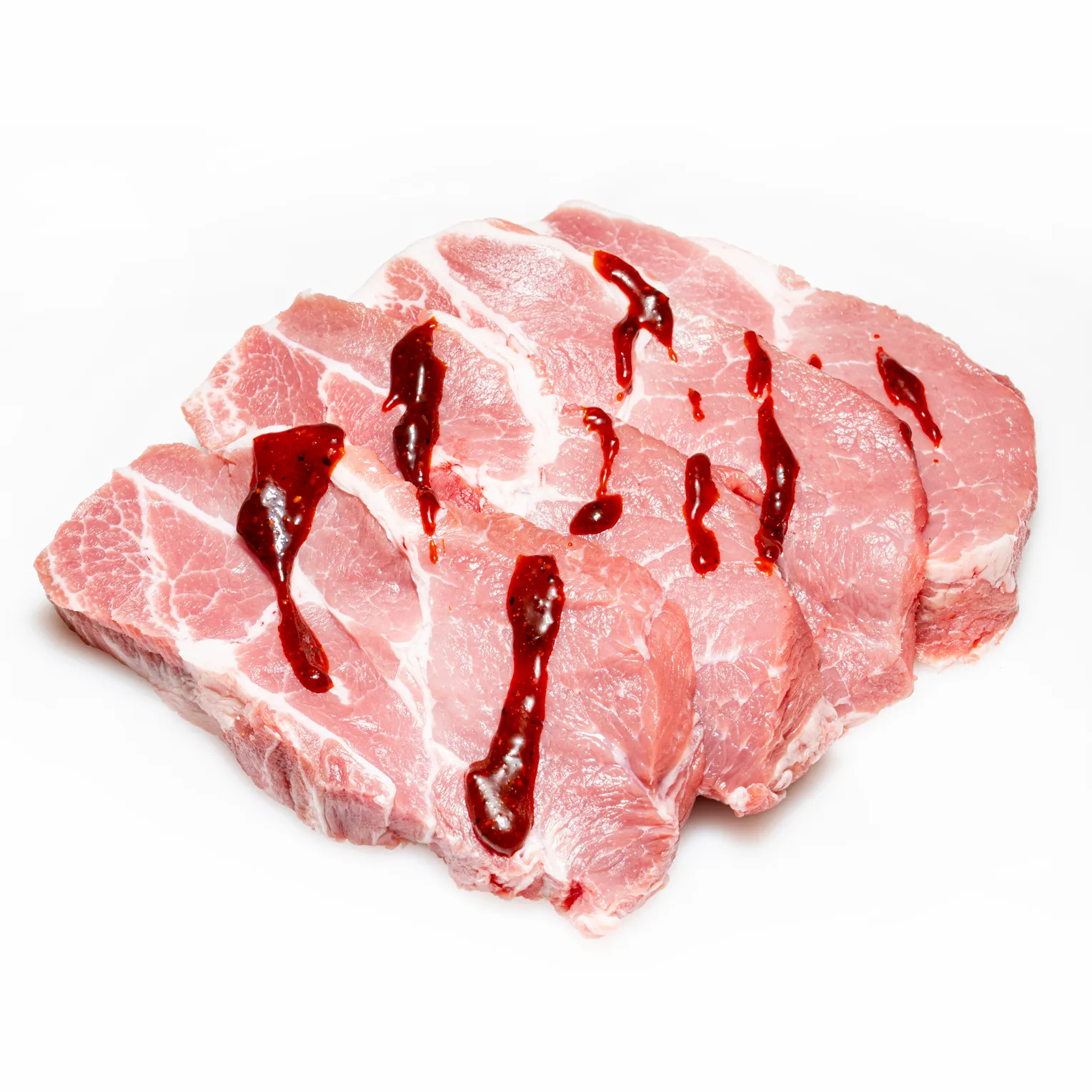 Schweinekammsteaks mit Tomaten-Pfeffer-Marinade drüber, auf weißem Hintergrund.
