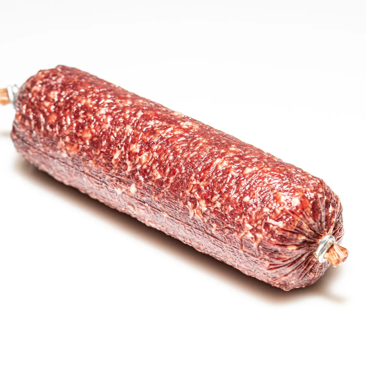Hauseigene Salami in klein vor weißem Hintergrund.
