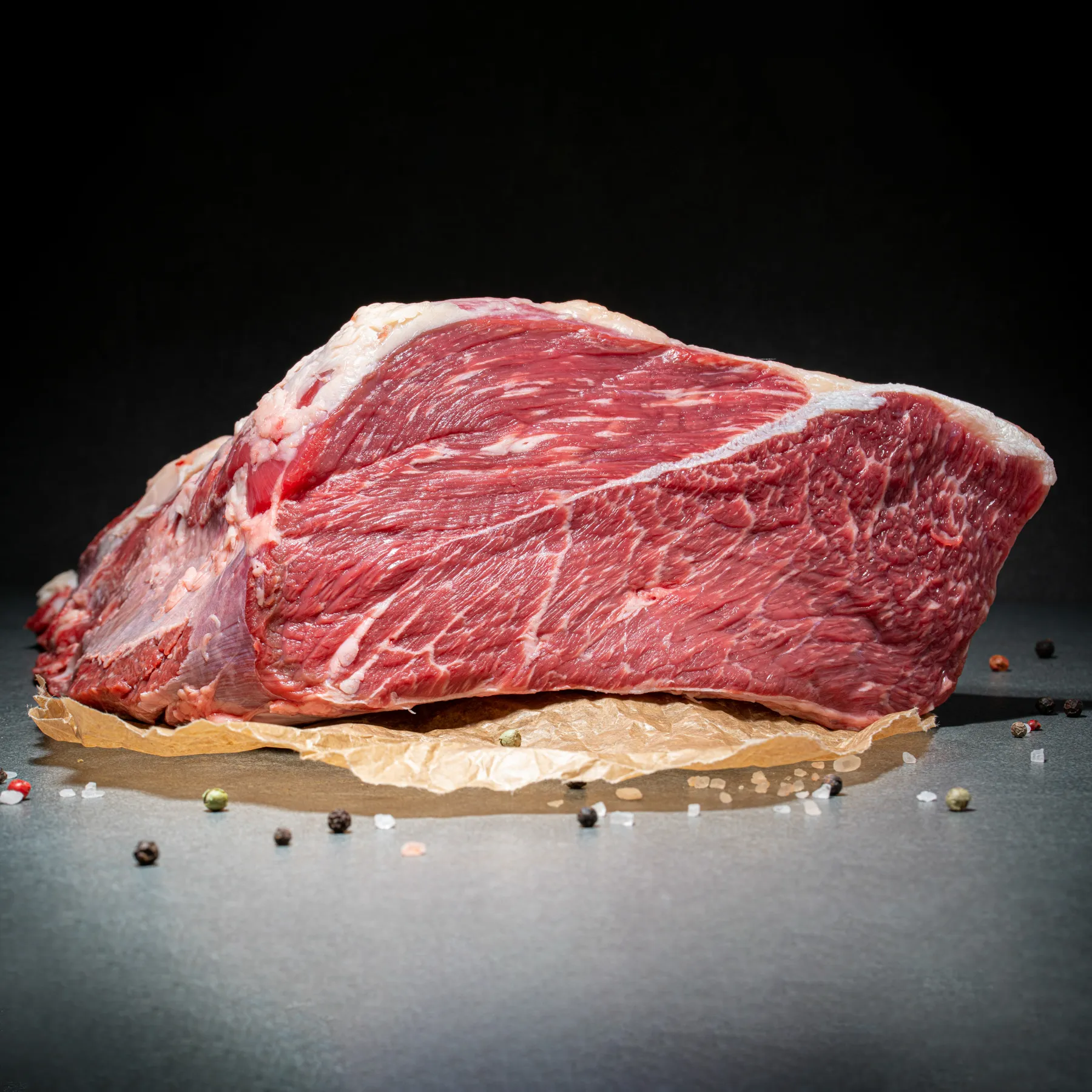 Rinderbraten Mittelbug vom Angus-Rind im Anschnitt auf Fleischpapier mit Deko.