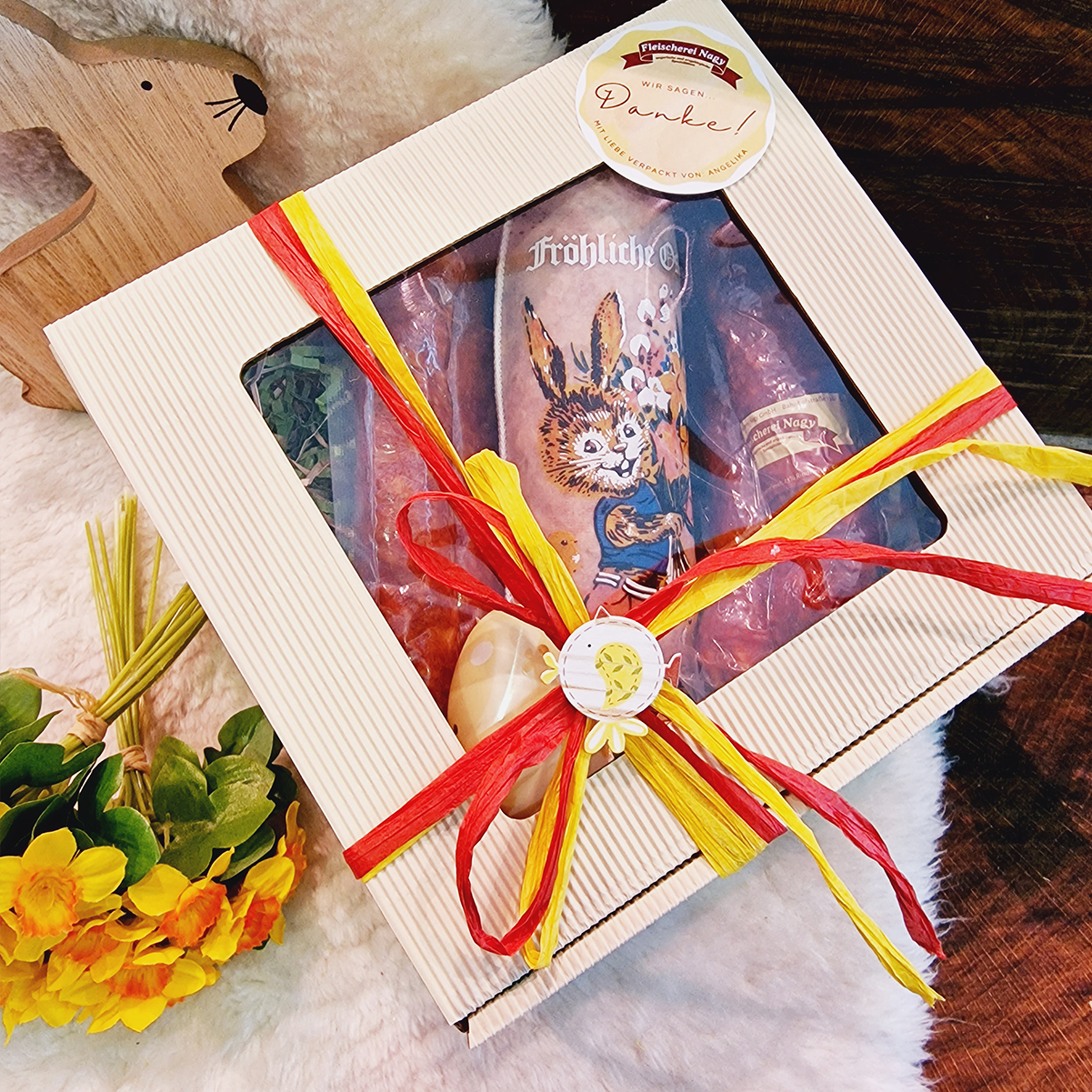 Zarte Ostergrüße Geschenkbox bestellen! Osterpräsent eingepackt mit Schleife und milden Wurstwaren wie Kümmelknacker als Inhalt.