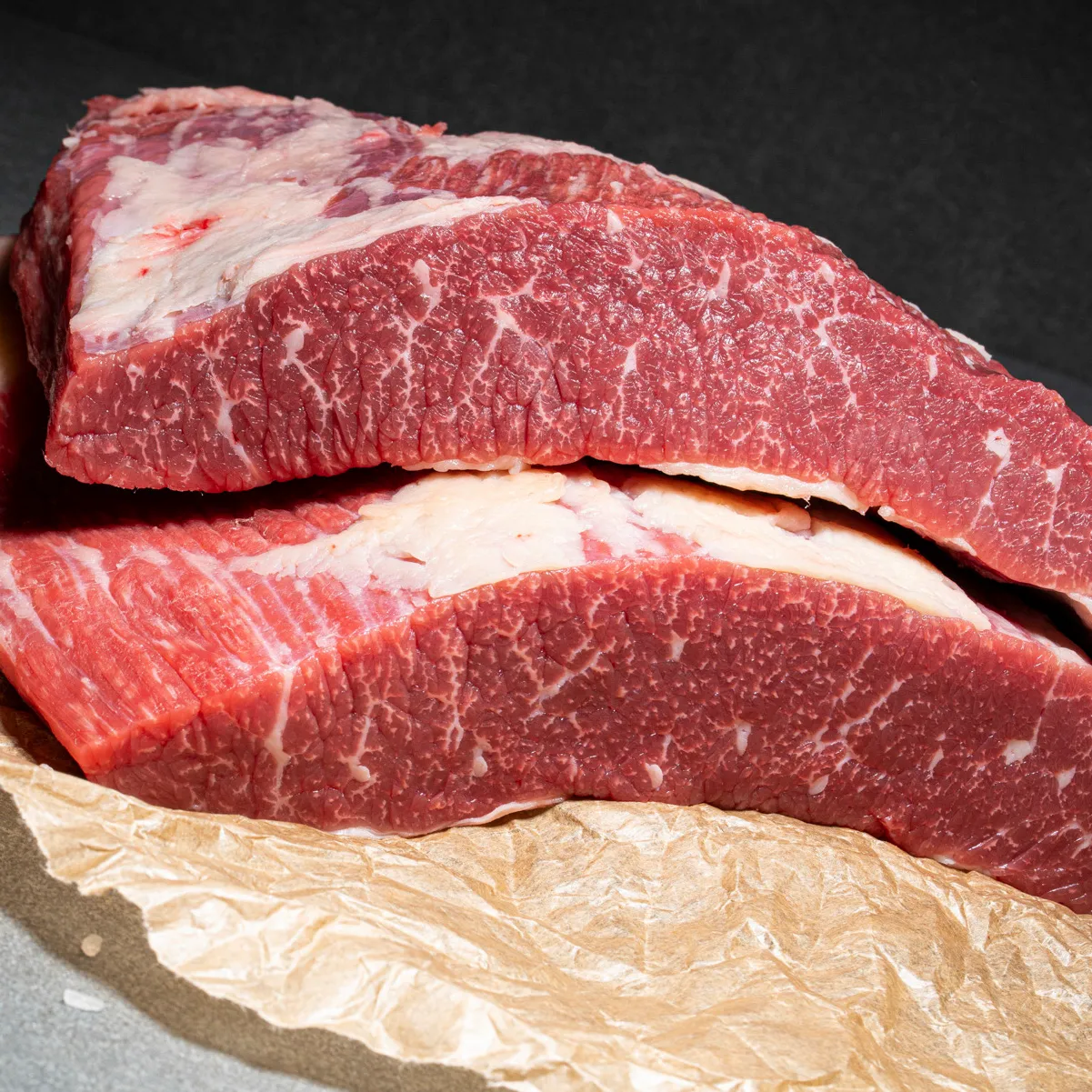 Flanksteak vom Angus Rind zwei Stück aufeinander und auf Fleischpapier platziert.