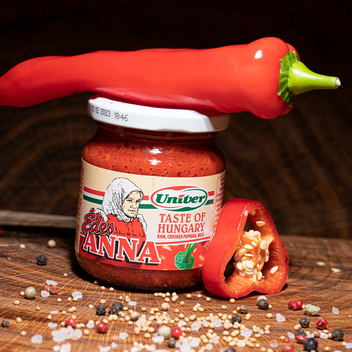 Ungarische Paprikacreme "süße Anna" bestellen. Ungarische Paprikacreme "süße Anna" mit einer Chilischote auf Holzbrett.